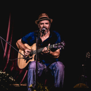 The image you uploaded appears to show a musician playing an acoustic guitar, performing on stage. Based on the file name, the musician is Rob Lutes, and the photography credit goes to Mark Robinson (Baristography).